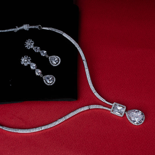 Diamond necklace and matching drop earrings set on red background