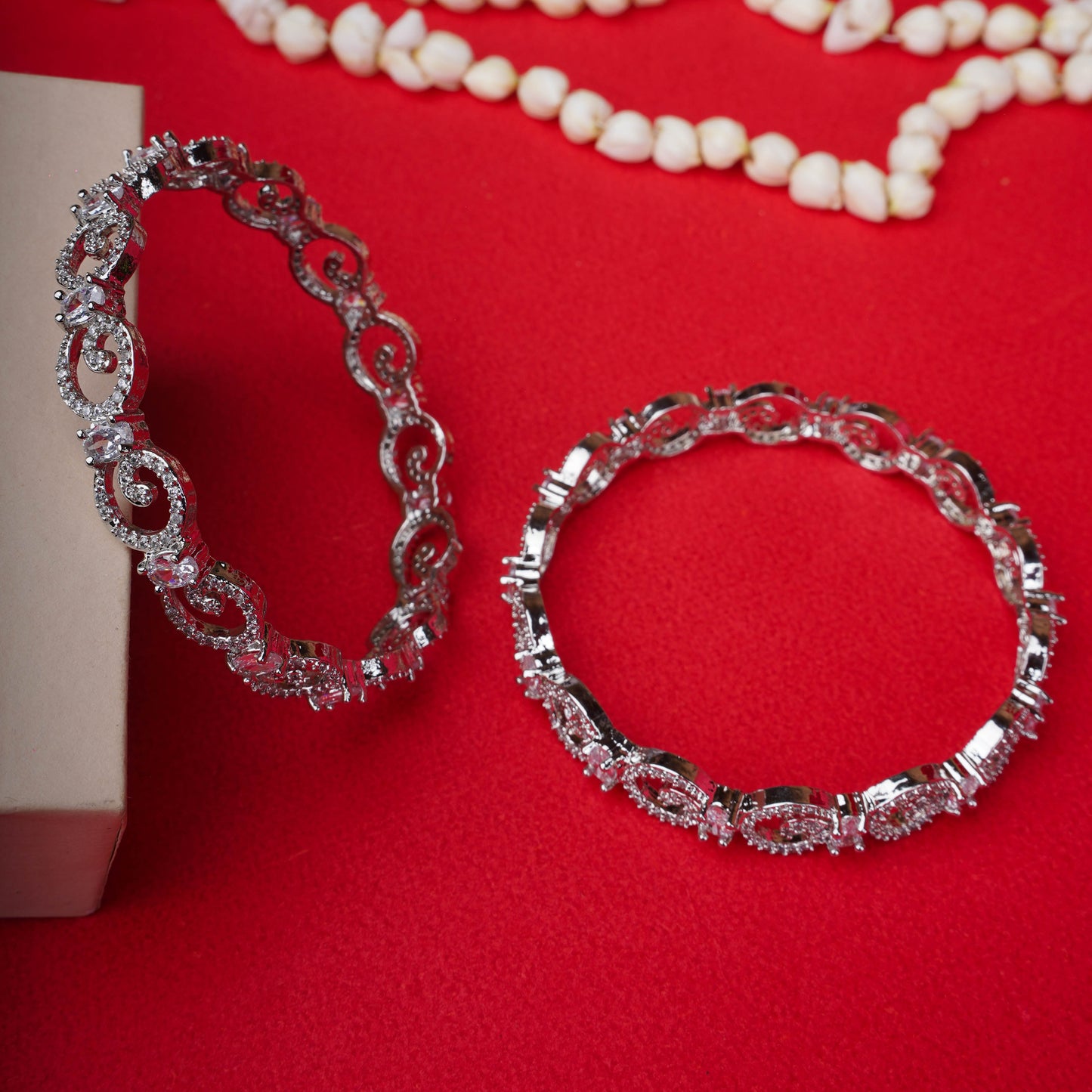 Silver loop crystal bangles on a black mannequin hand - Revaaj Ground