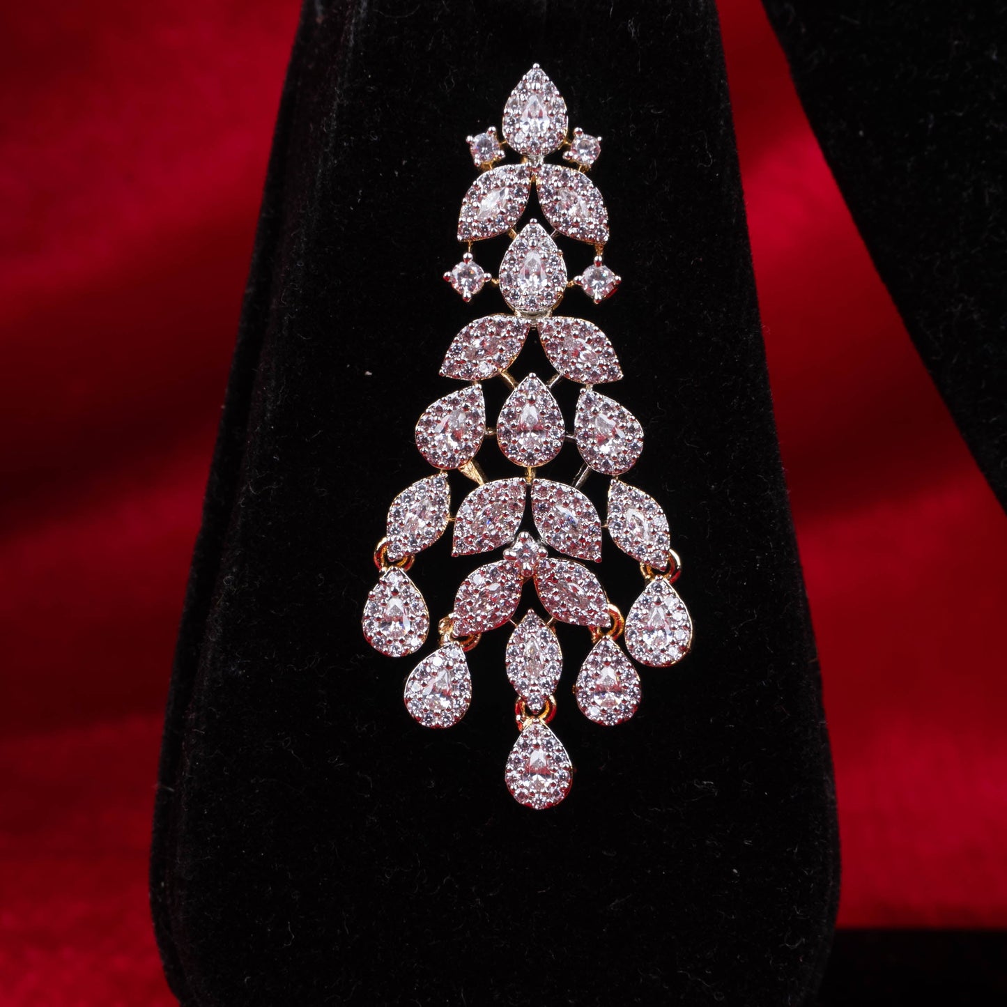Silver-tone cascading leaf drop necklace and earrings set with synthetic stones on a black display - Revaaj Ground