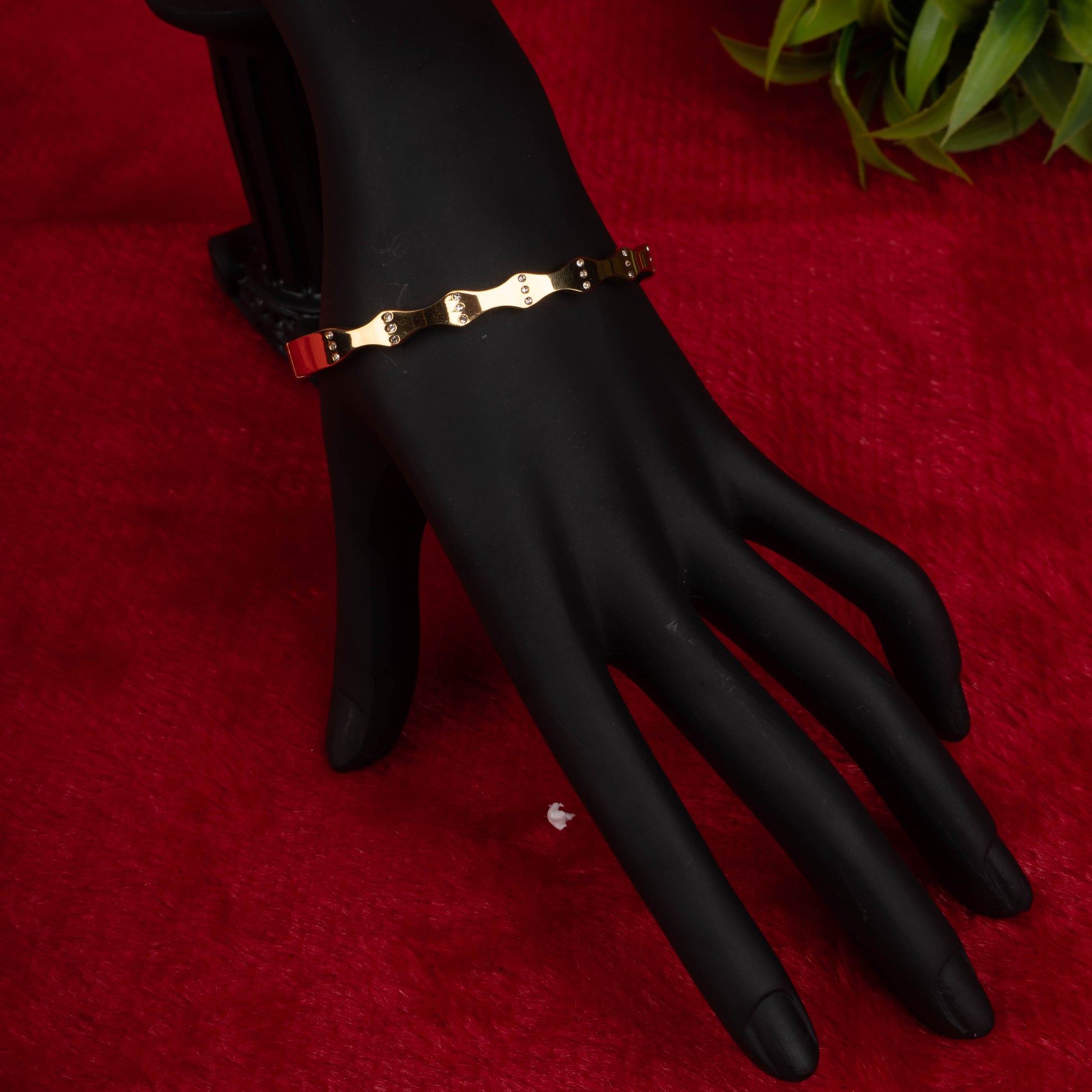 Gold-tone fashion bracelet with industrial link design on black mannequin hand - Revaaj Ground