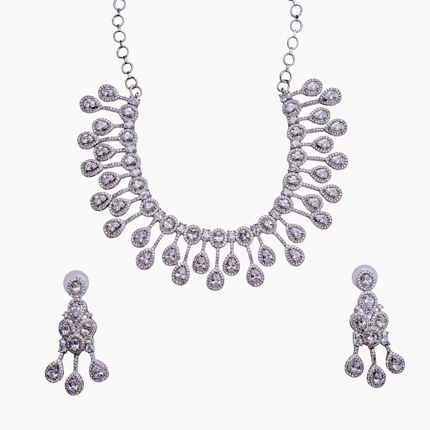 Silver necklace and earring set with teardrop diamond accents on white background
