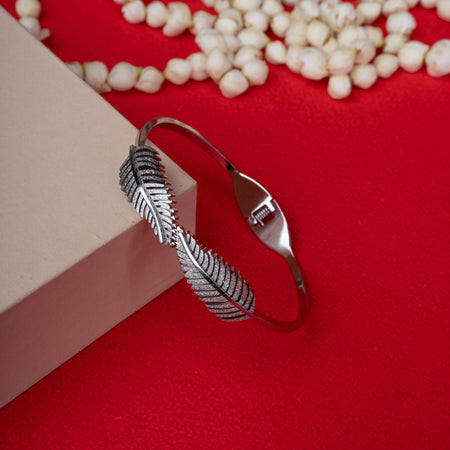 Silver-tone bangle with two detailed feather designs and a textured band - Revaaj
