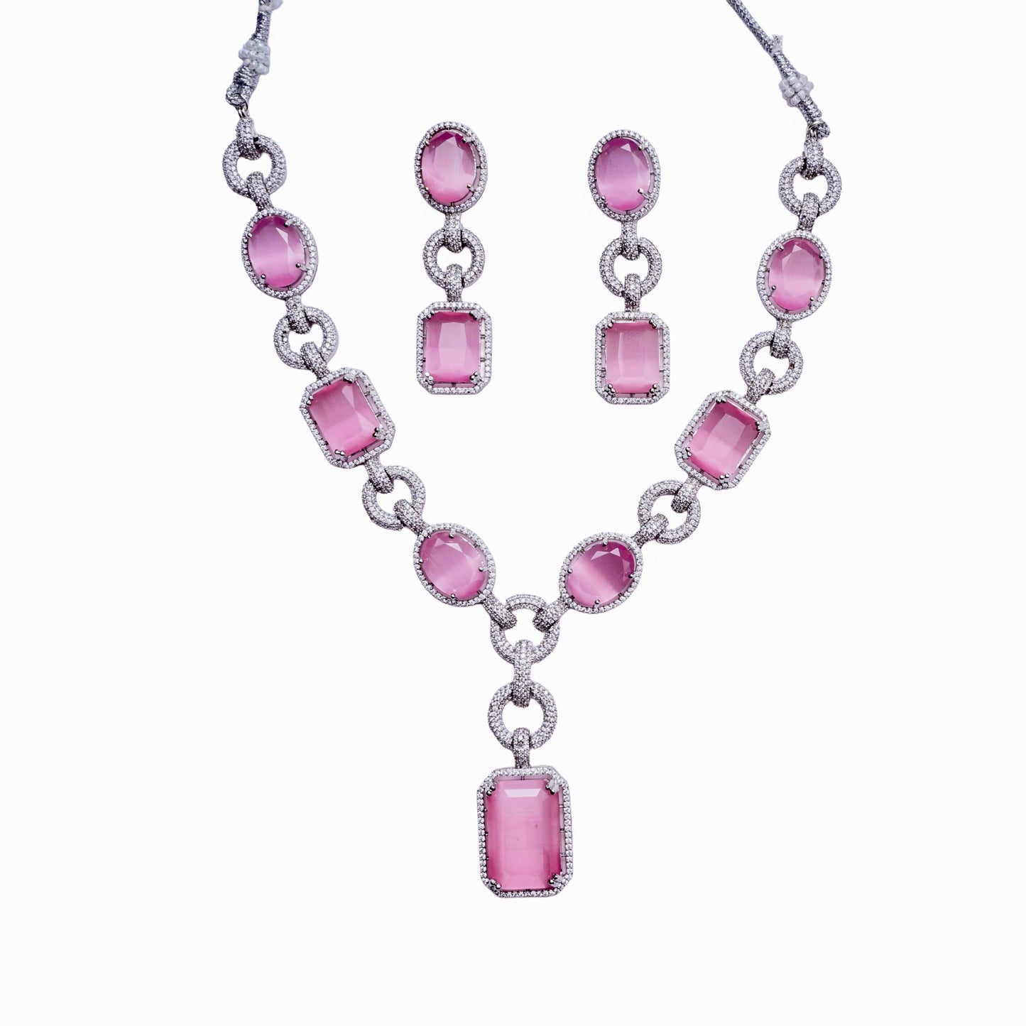 Silver necklace and earring set with oval and rectangular pink gemstones on white background