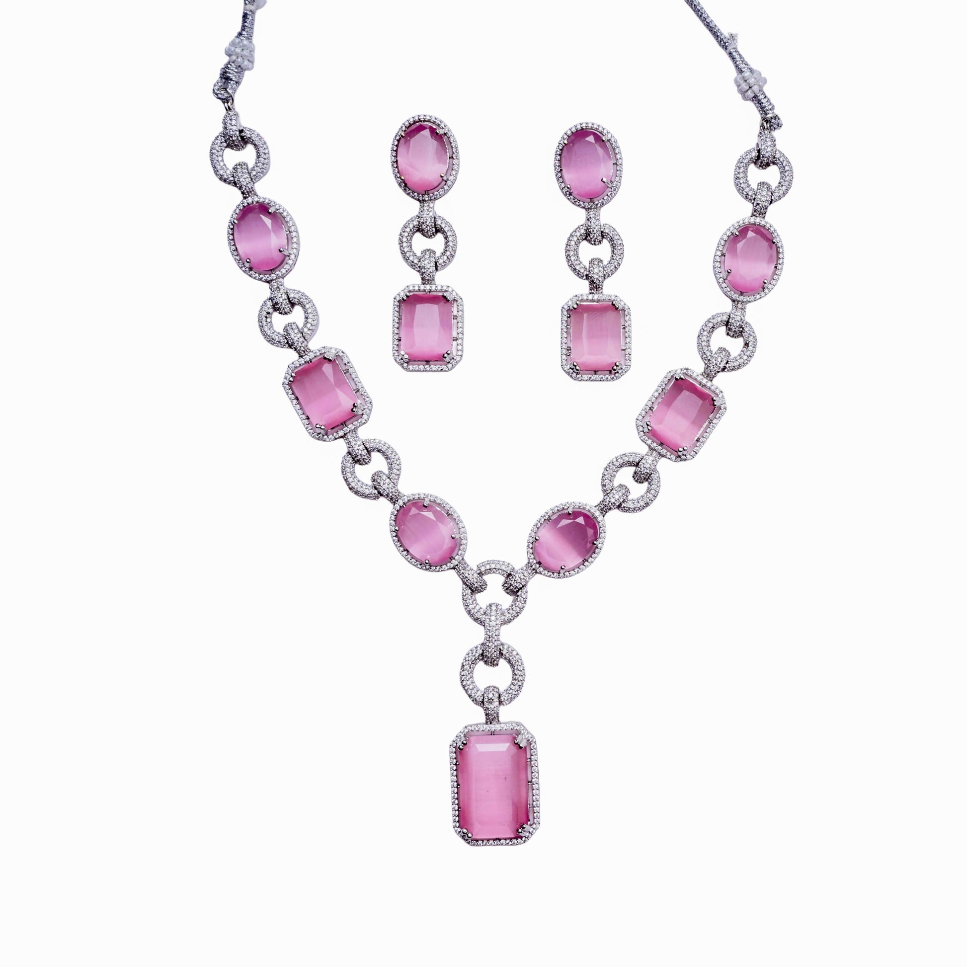 Silver necklace and earring set with oval and rectangular pink gemstones on white background