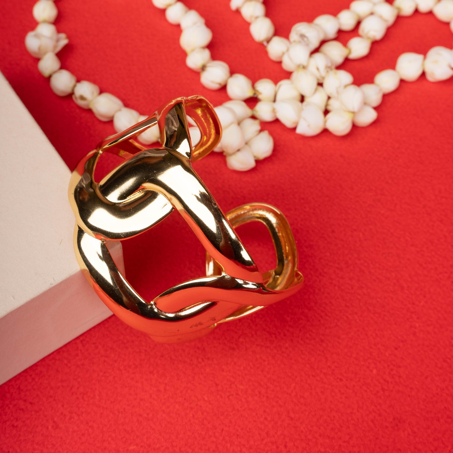 Wide gold-tone open cuff bracelet with a chunky chain link design on a ground background - Revaaj