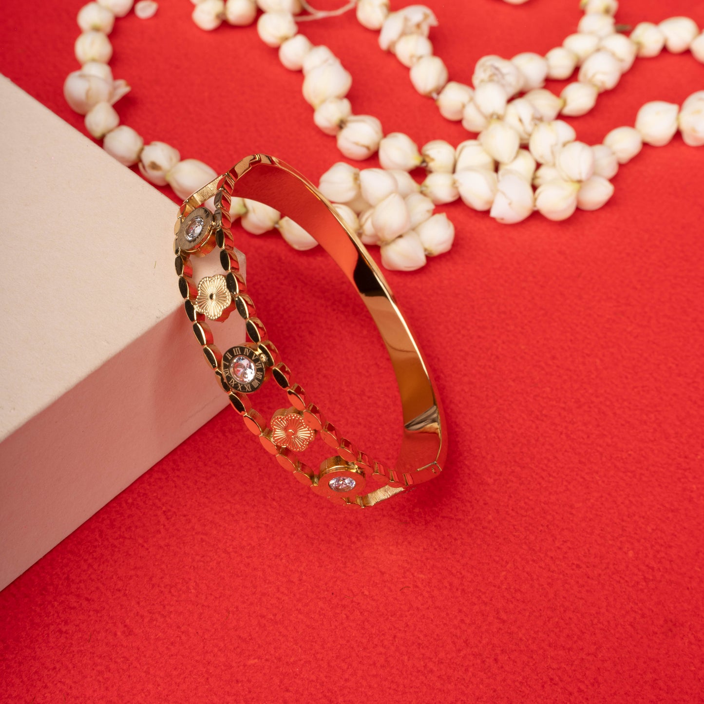 Gold-tone bracelet with roman numeral and flower motifs, accented by crystals - Revaaj