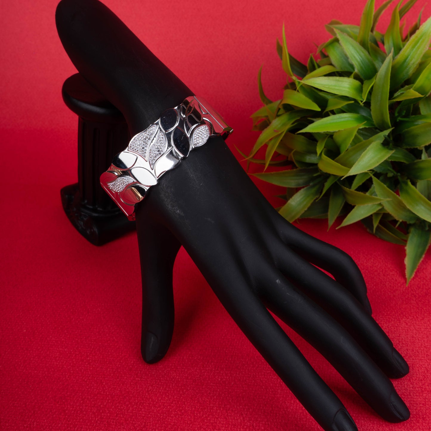 Wide silver-tone hinged bracelet with intricate leaf or floral motifs, combining a smooth polished finish and sparkling pave crystals - Revaaj