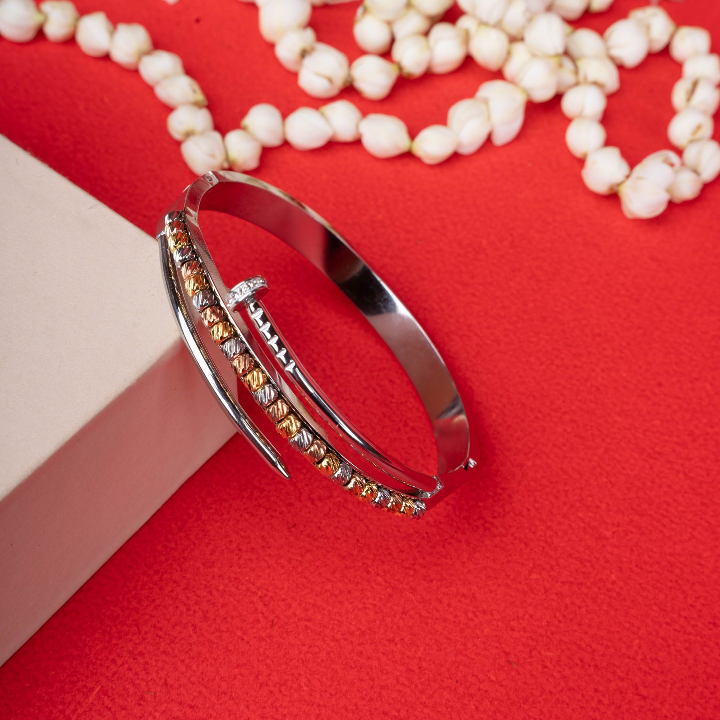 Silver-tone hinged bracelet with a curved nail design and a second band featuring multi-colored textured beads white background - Revaaj