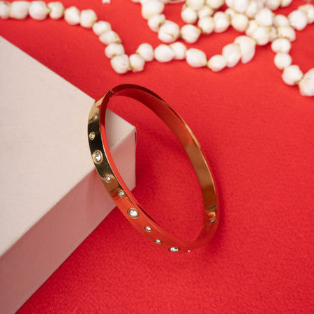 Gold-tone hinged bracelet with a half-circle design featuring a line of small, sparkling crystals - Revaaj