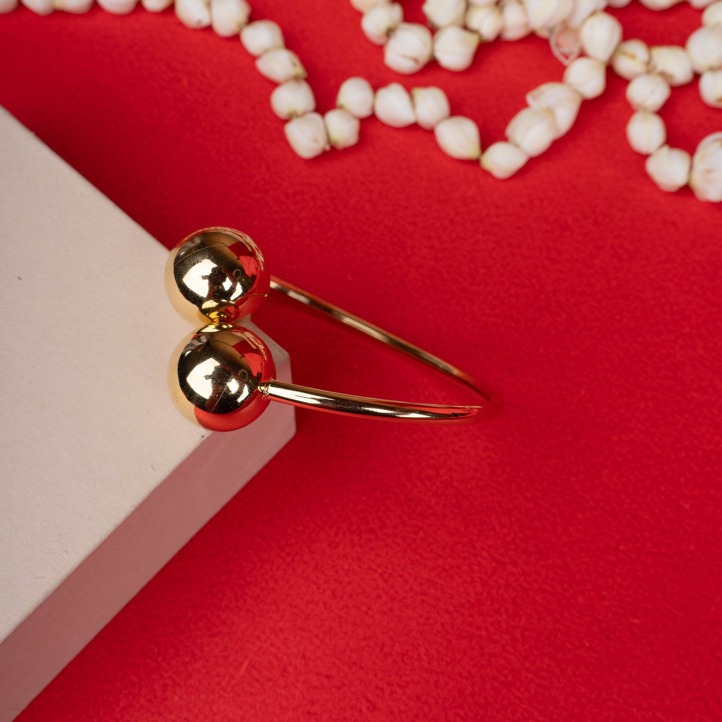 Gold-tone open bangle bracelet with dual polished spheres white backgroung - Revaaj