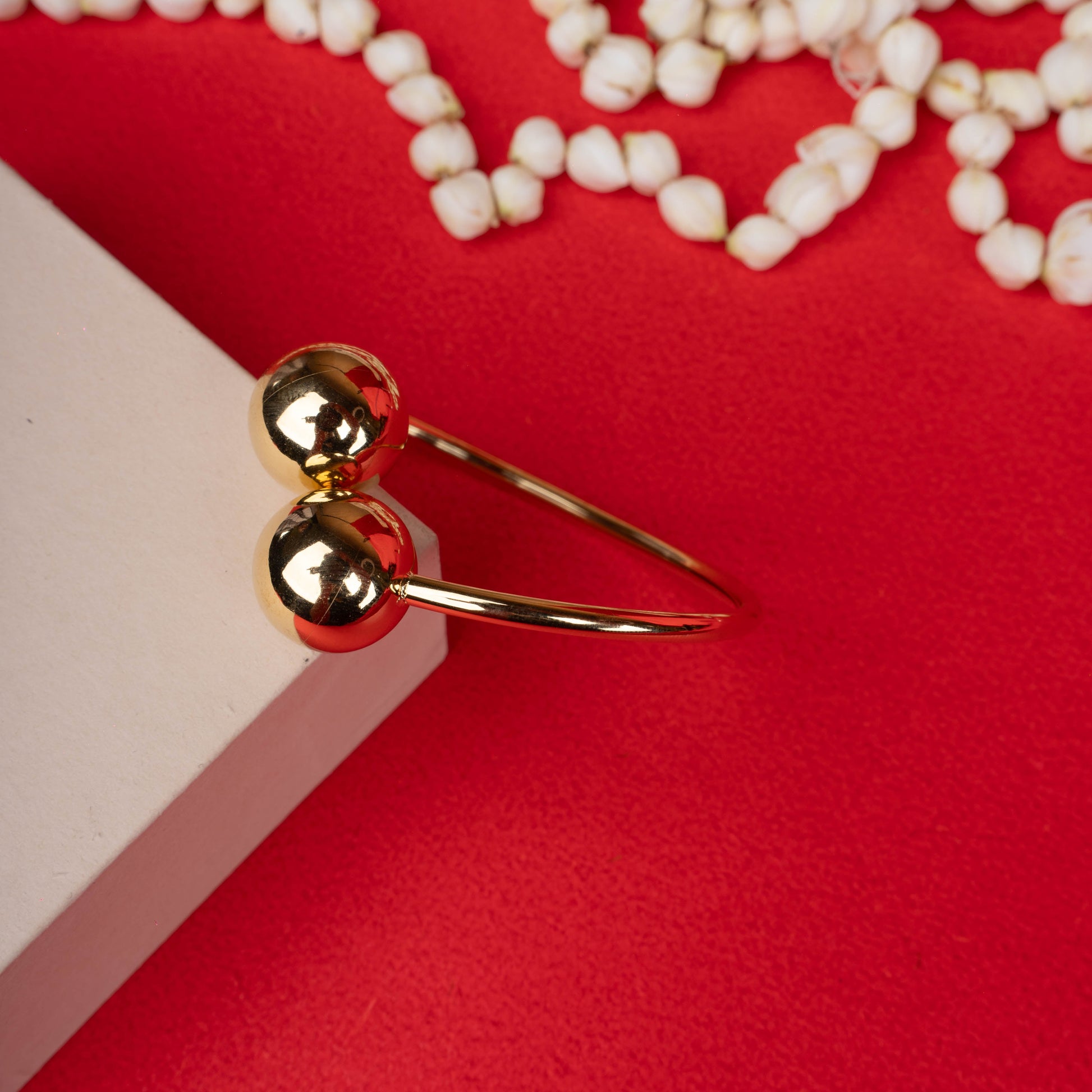Gold-tone open bangle bracelet with dual polished spheres white backgroung - Revaaj