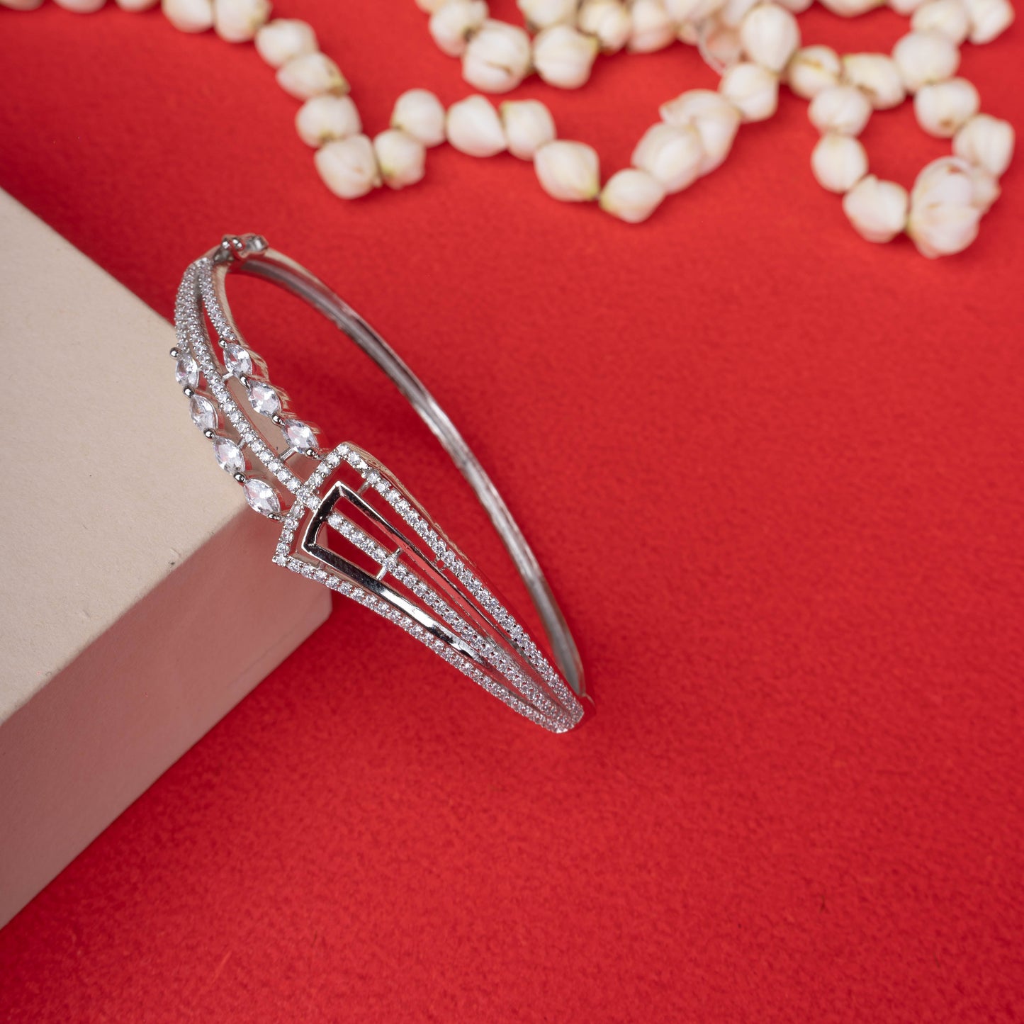 Silver-tone hinged bracelet with a sparkling geometric design, featuring pave crystals and marquise-cut crystal accents white background - Revaaj
