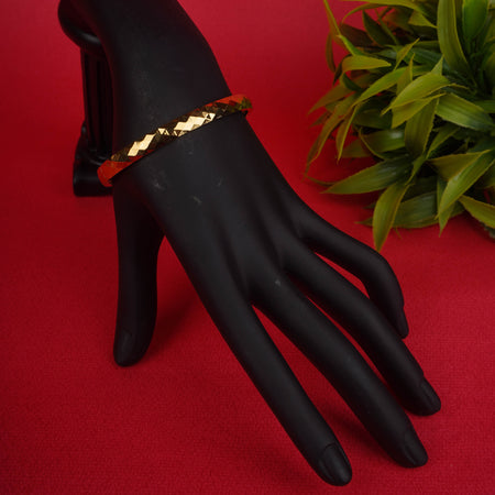 Gold-tone hinged bracelet with a faceted, geometric texture on one side and a polished, smooth surface on the other - Revaaj