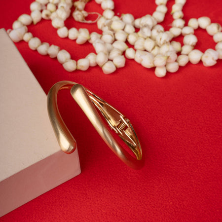 Minimalist gold-tone open cuff bracelet with a single small crystal accent white image - Revaaj
