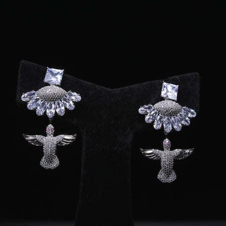 Angel wing designer earrings with crystal embellishments and square-cut stones displayed on black stand