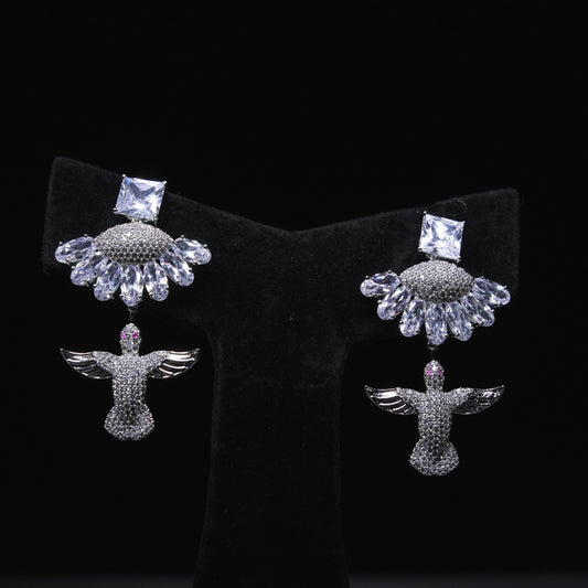 Angel wing designer earrings with crystal embellishments and square-cut stones displayed on black stand
