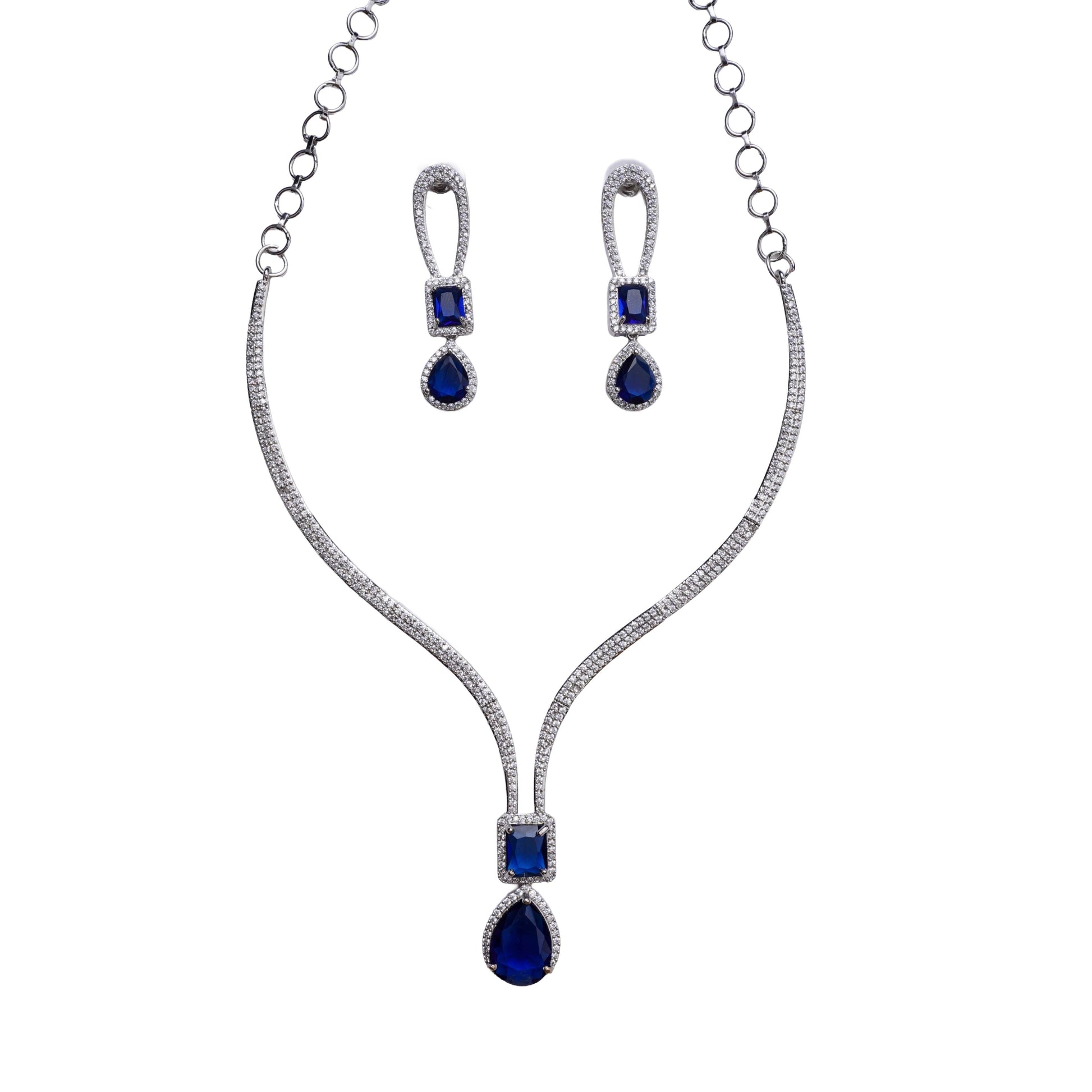 Necklace and earring set with blue rectangular and teardrop stones in halo setting on white background