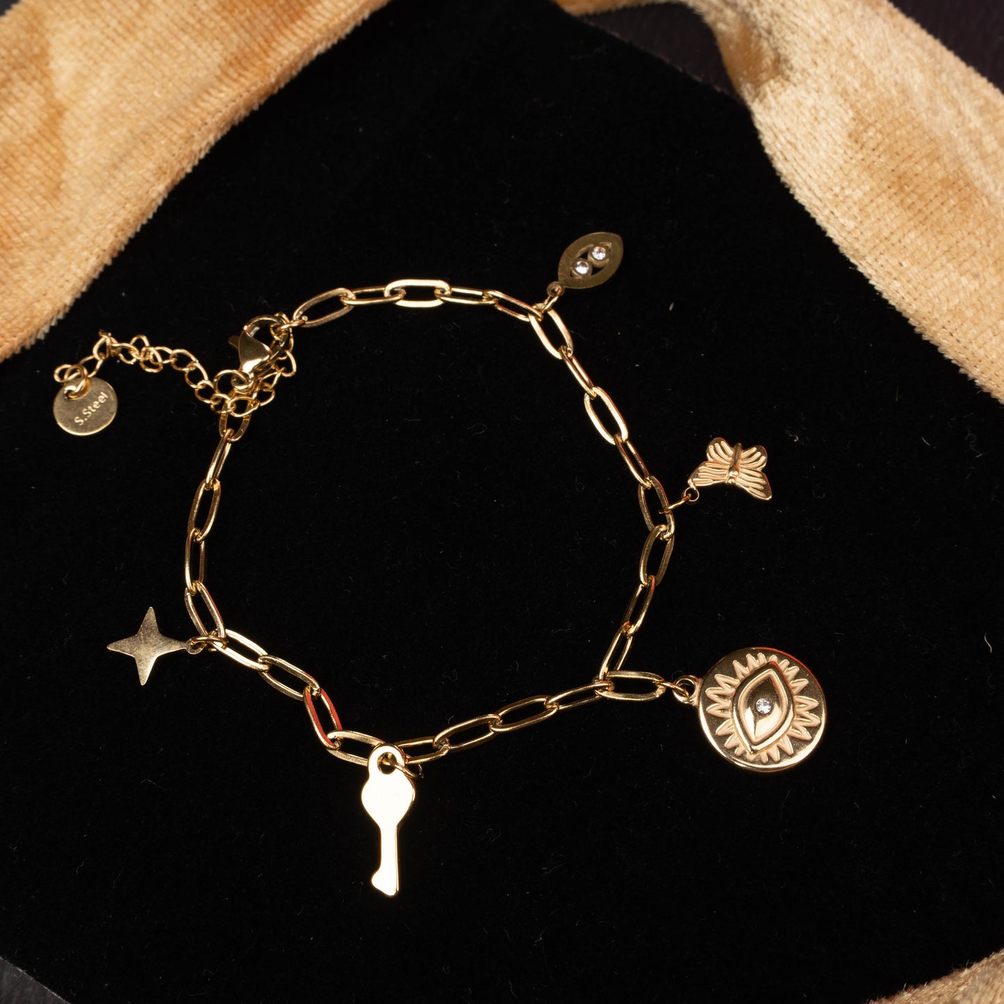 Gold paperclip chain bracelet with butterfly, key, and textured medallion charms second view - Revaaj