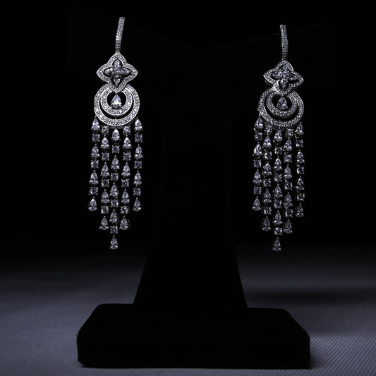 Luxury long drop earrings with cascading crystal strands displayed on black stand