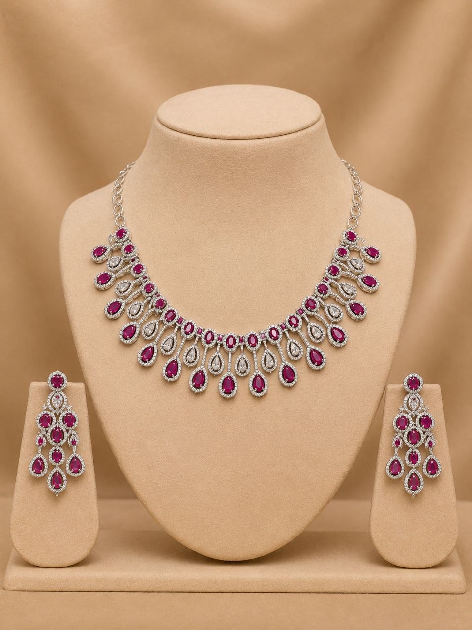 Elegant ruby red and clear stone teardrop necklace with matching dangling earrings on black velvet bust display 3