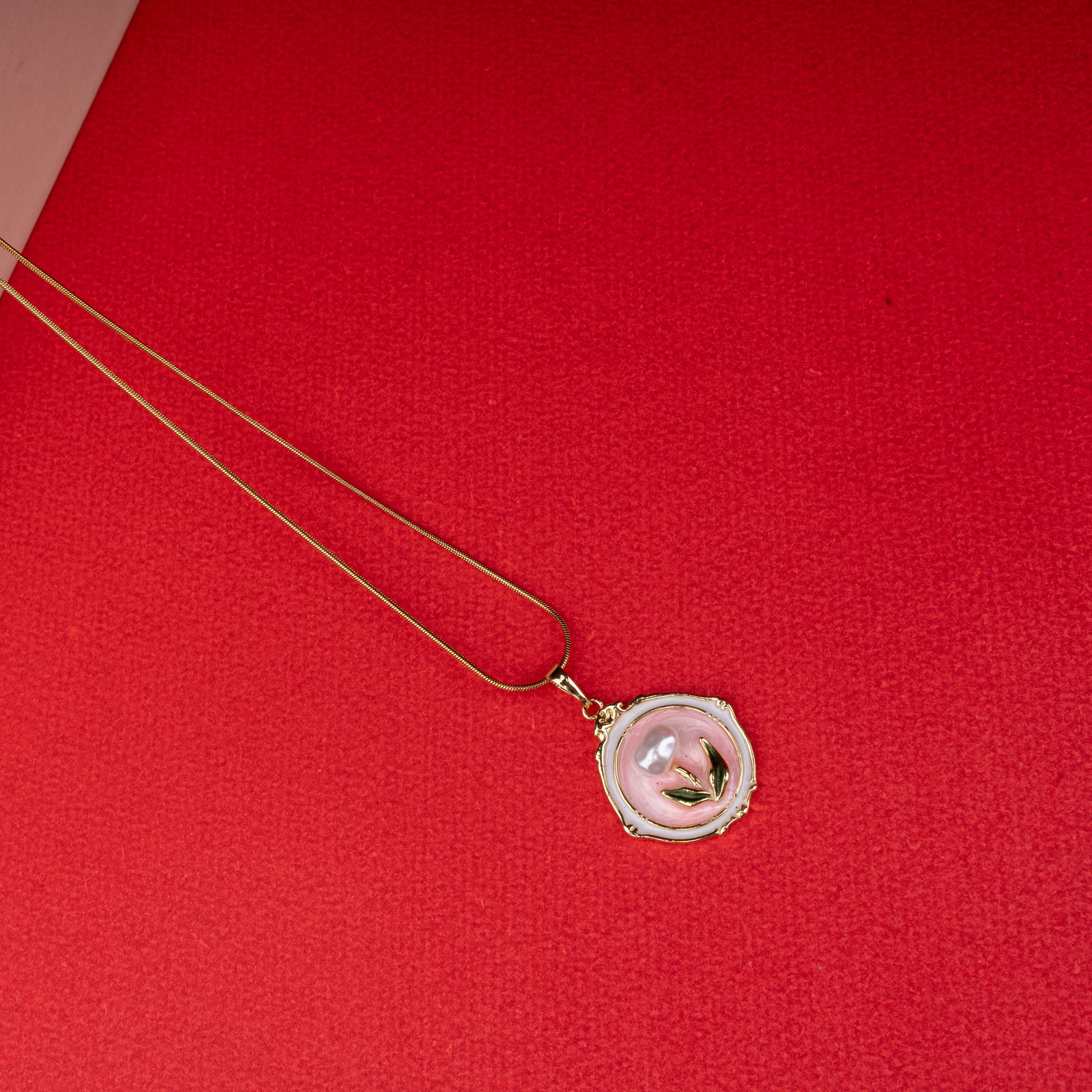 Gold chain necklace with round pink mother-of-pearl pendant featuring gold leaf design - Revaaj