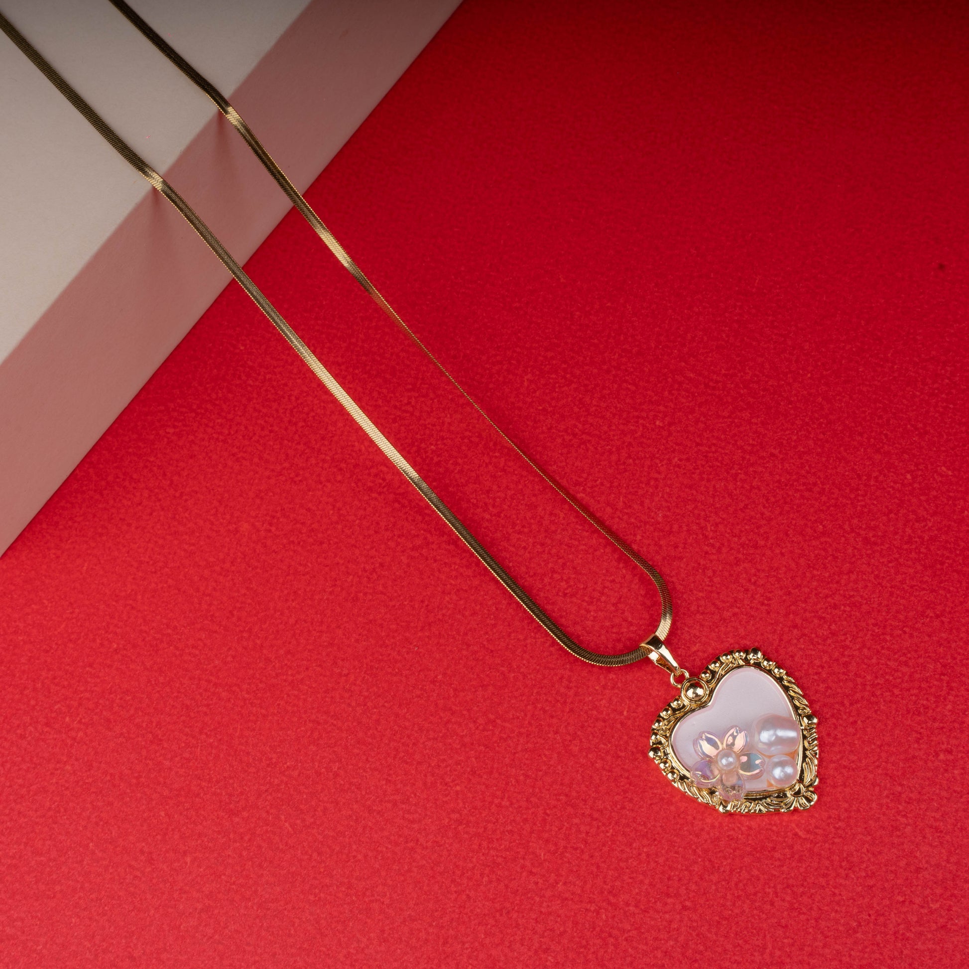 Gold necklace with textured chain and pink enamel pendant featuring a gold butterfly - Revaaj