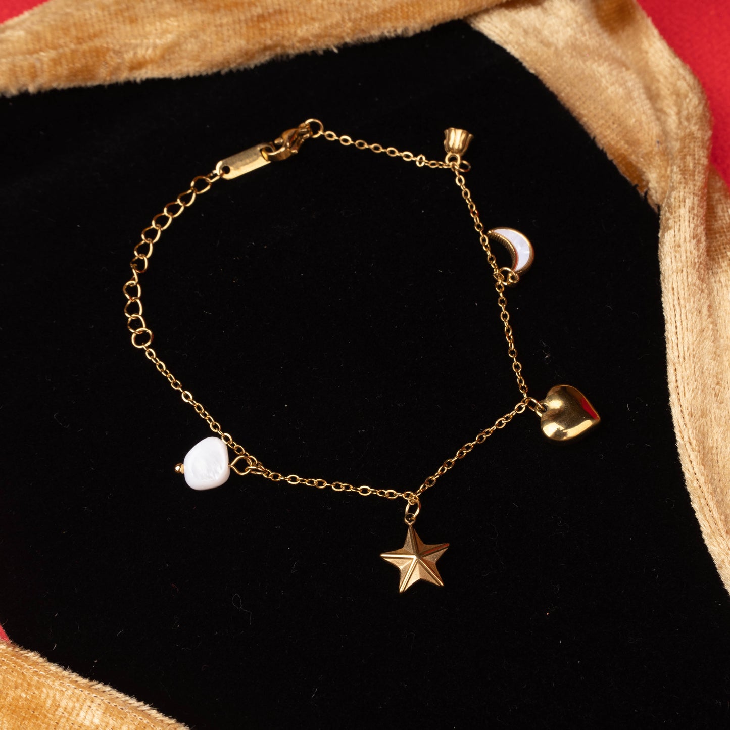 Gold charm bracelet with moon, star, heart, and pearl-like charms zommed image  – Revaaj