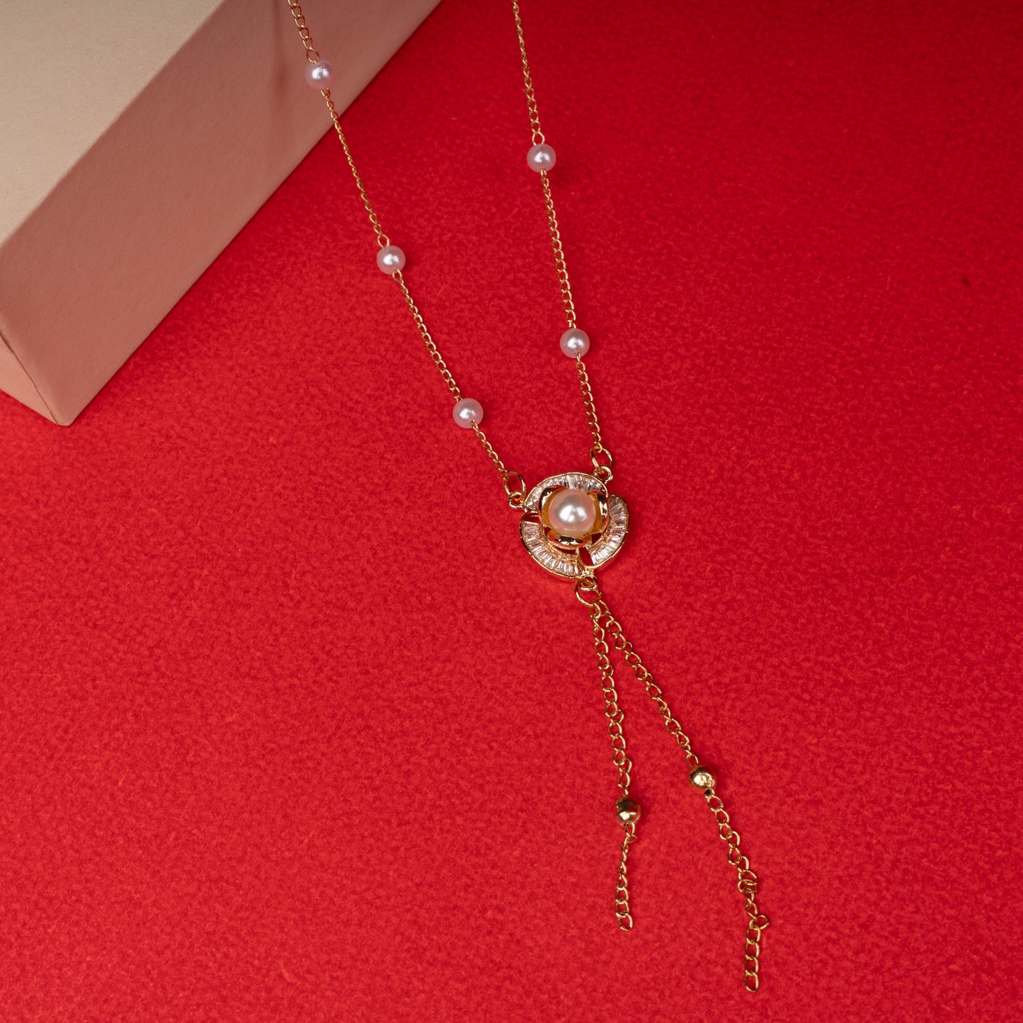 Gold pearl drop necklace with central crystal pendant floored image - Revaaj