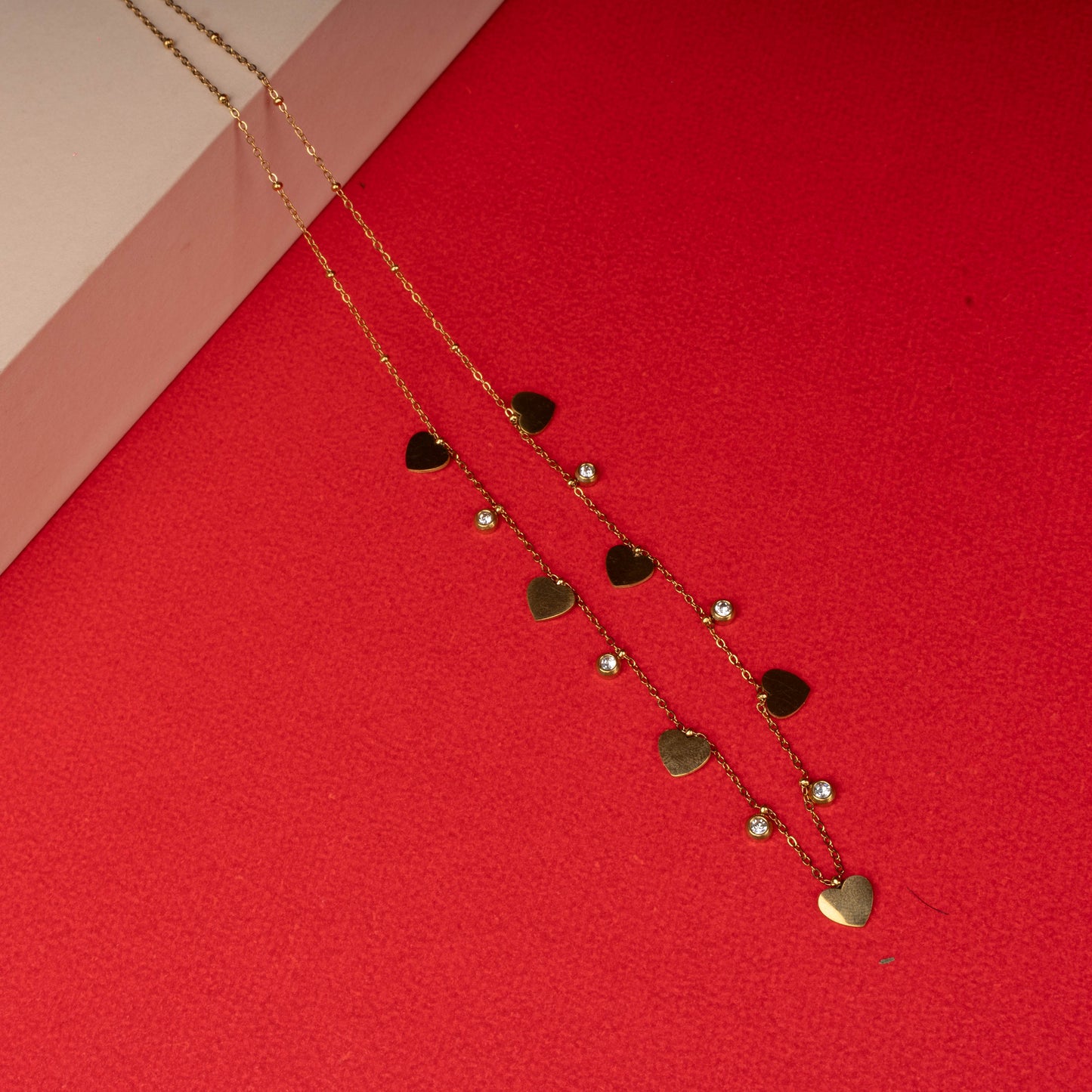 Gold necklace with alternating heart charms and crystals floored image- Revaaj