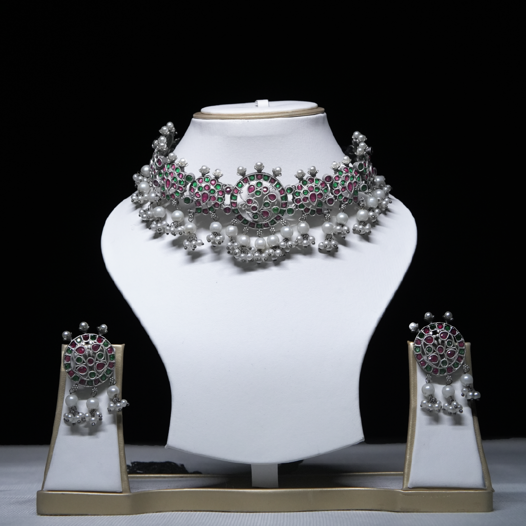 Revaaj Kundan Choker Necklace Set with matching earrings displayed on a white mannequin.  The necklace features pink and green gemstones and pearls.