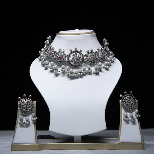 Revaaj Kundan Choker Necklace Set with matching earrings displayed on a white mannequin.  The necklace features pink and green gemstones and pearls.