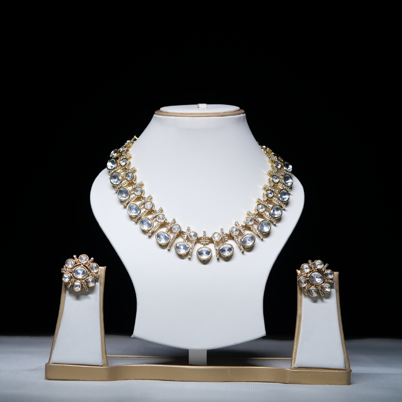 Revaaj Kundan Necklace Set displayed on a white jewelry stand, showcasing the necklace and matching earrings with intricate gold and kundan detailing.