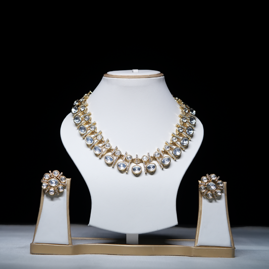 Revaaj Kundan Necklace Set displayed on a white jewelry stand, showcasing the necklace and matching earrings with intricate gold and kundan detailing.