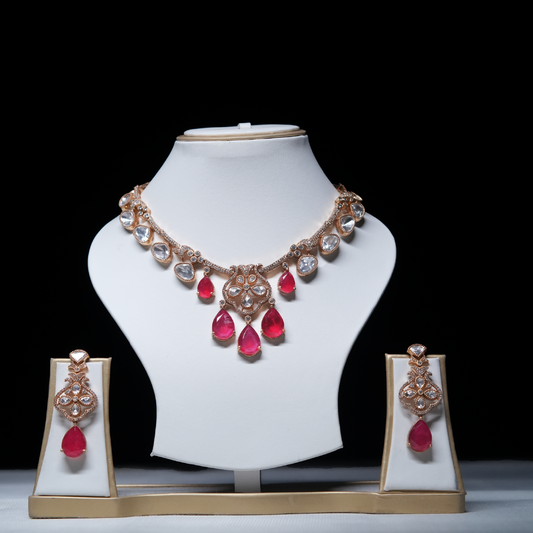 Revaaj Kundan necklace set with red and white gemstones displayed on a mannequin.  The set includes a necklace and matching earrings.