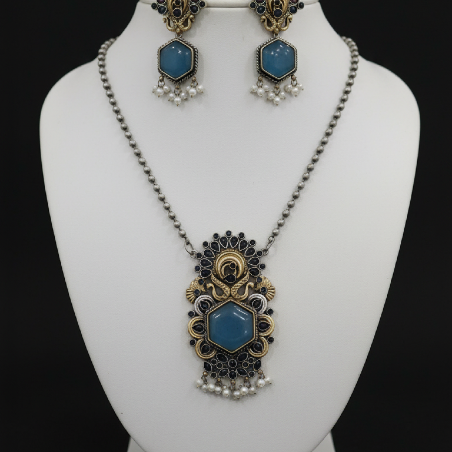 Antique peacock necklace set with blue gemstone pendant, pearl drops, and matching earrings in gold finish Stand