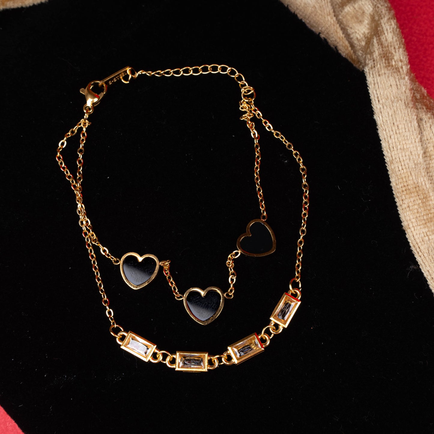 Gold-tone dual layer bracelet with black heart charms and rectangular crystal accents second view - Revaaj