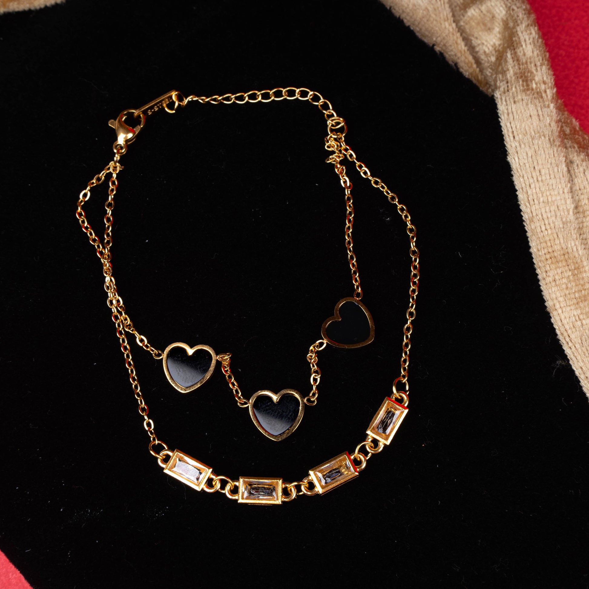 Gold-tone dual layer bracelet with black heart charms and rectangular crystal accents second view - Revaaj