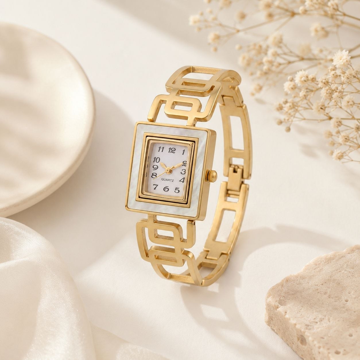 Gold square face women's watch with white mother of pearl dial and geometric link bracelet displayed on white background 3