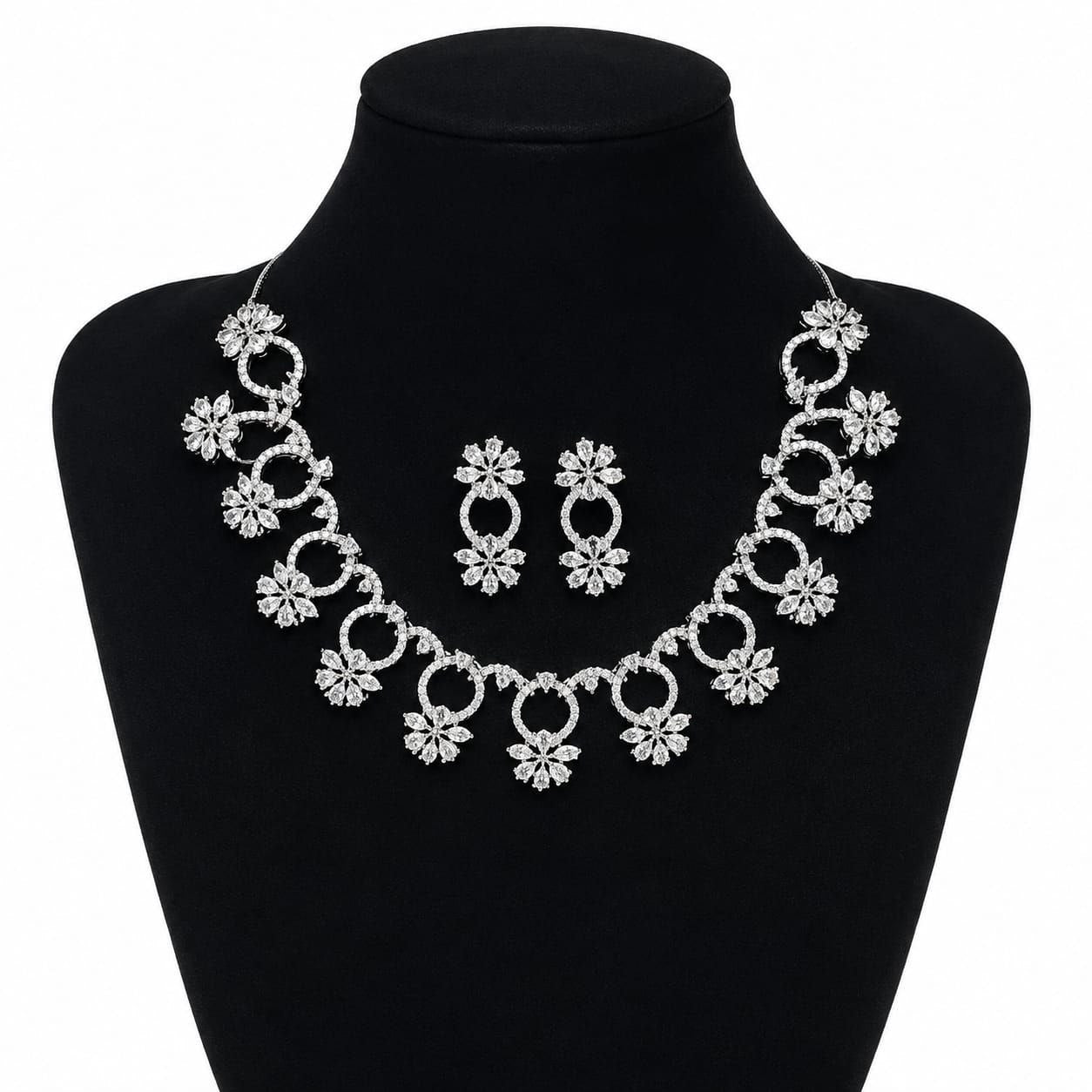 Premium silver floral necklace with crystal accents and matching earrings displayed on black bust 1