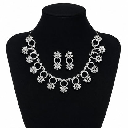 Premium silver floral necklace with crystal accents and matching earrings displayed on black bust 1