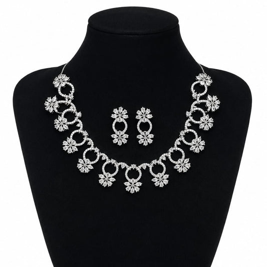Premium silver floral necklace with crystal accents and matching earrings displayed on black bust 1