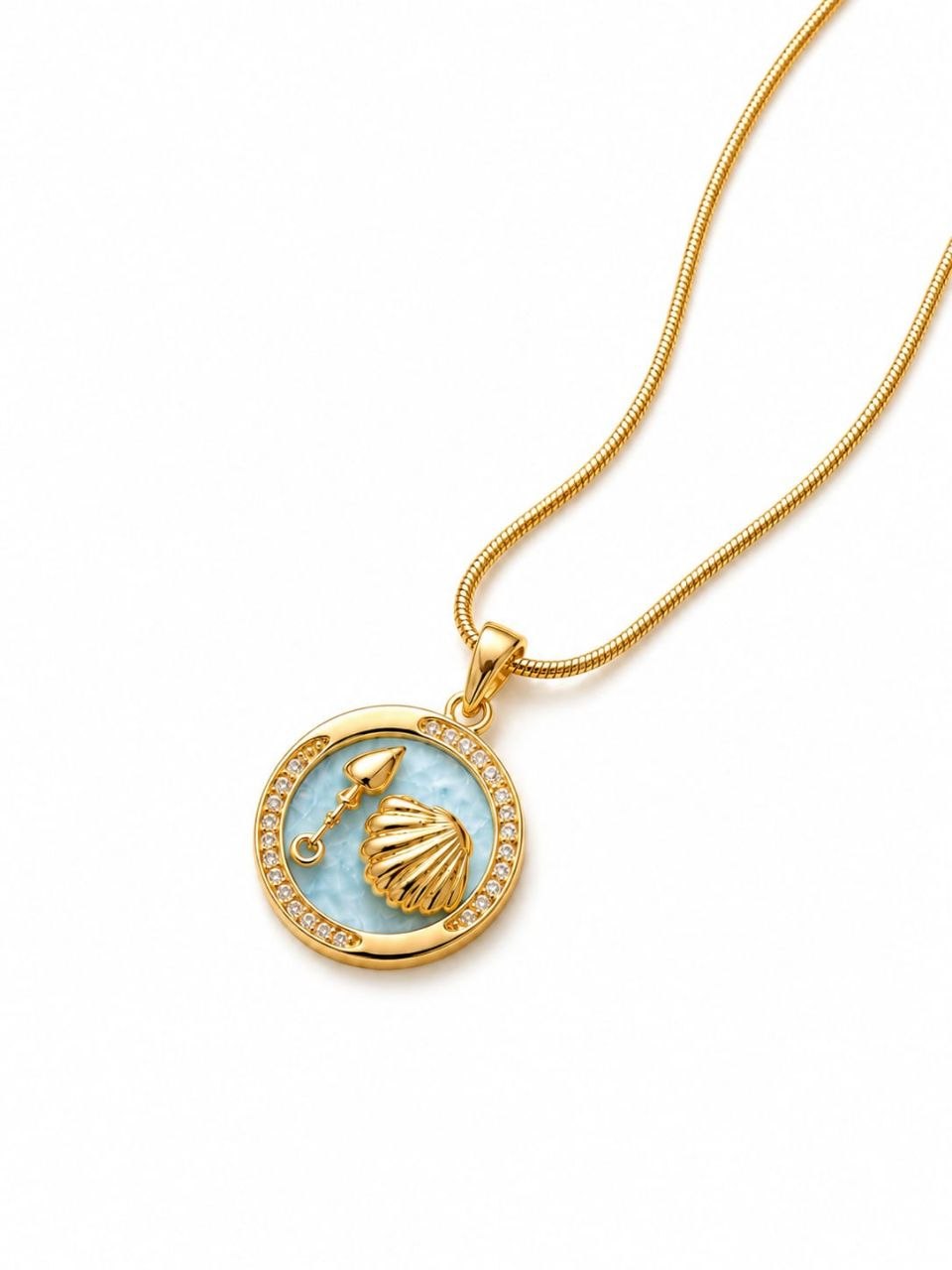 Gold plated necklace with circular light blue enamel pendant featuring golden seashell and spade charm surrounded by sparkling crystals on snake chain 1
