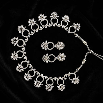 Premium silver floral necklace with crystal accents and matching earrings displayed on black bust 3