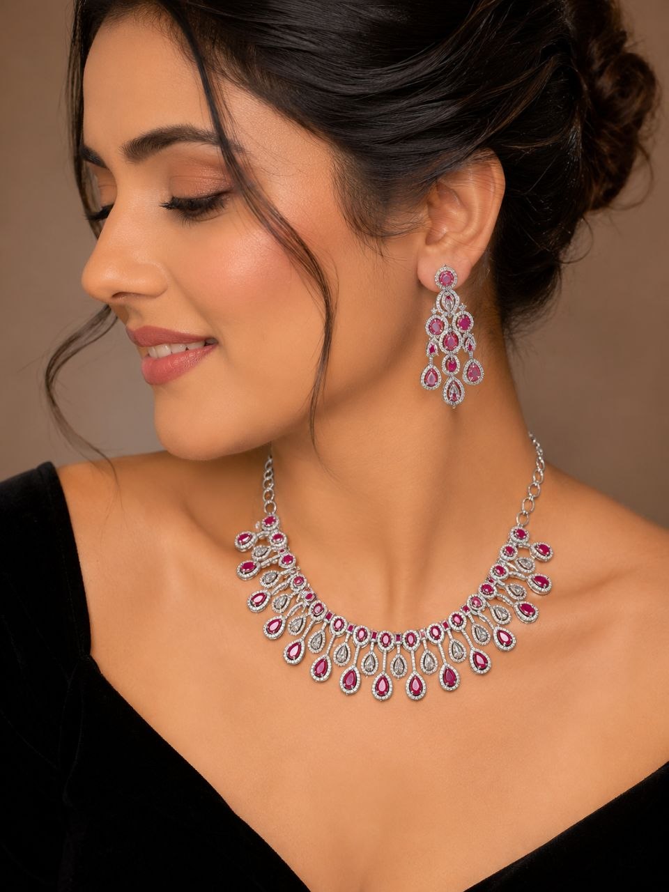 Elegant ruby red and clear stone teardrop necklace with matching dangling earrings on black velvet bust display 2