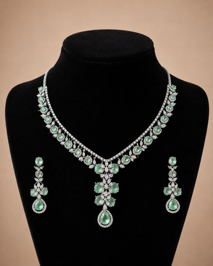 Mint green floral gemstone necklace with matching drop earrings set featuring clear stones on beige display bust 3