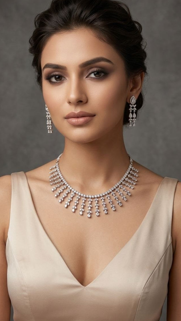 Premium silver fringe necklace with cascading crystal tassels and matching drop earrings displayed on white velvet fabric 2