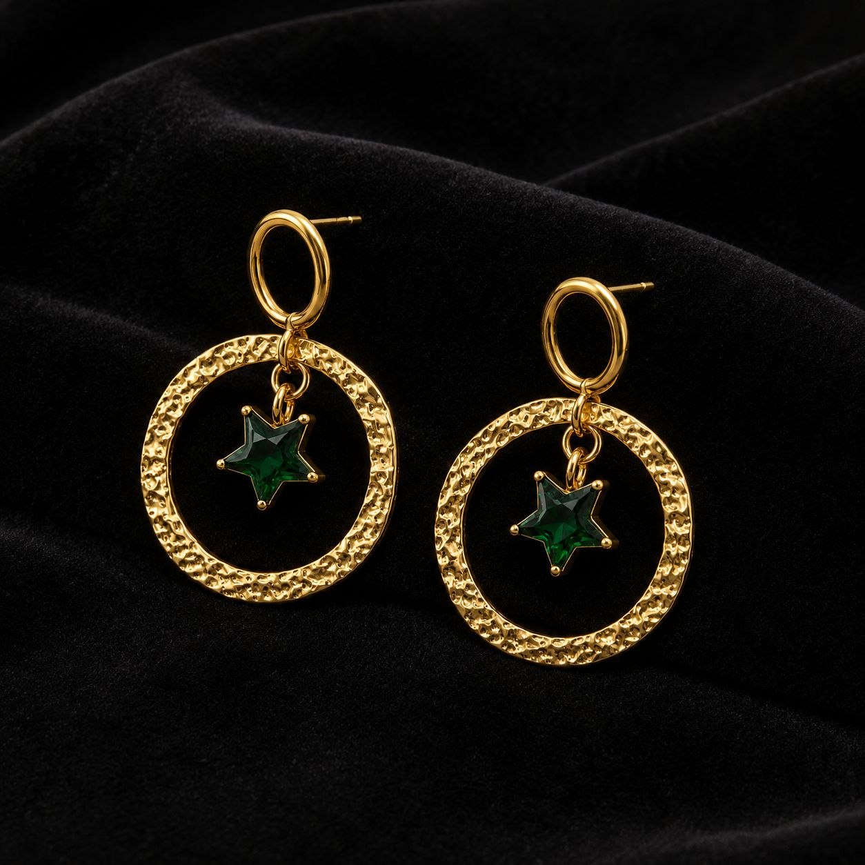 Pair of gold hammered circular hoop earrings with dangling green star crystal pendants on white background 3
