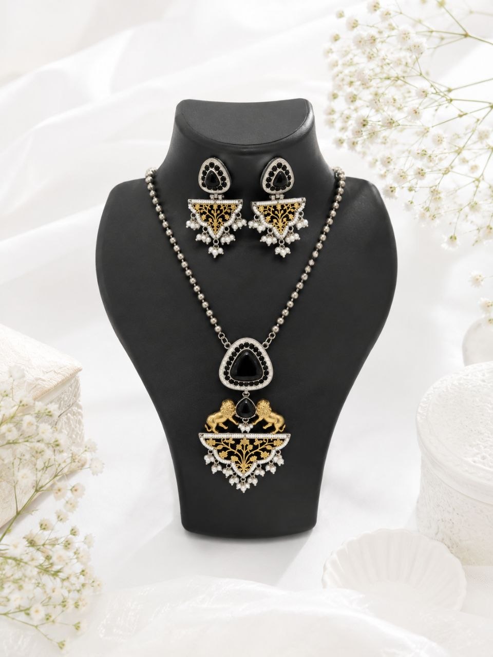 Royal black and gold Indian necklace set with lion motifs, large black stone pendant, pearl details and matching drop earrings on black display bust 1
