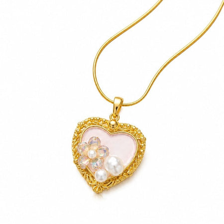 Gold heart-shaped pendant necklace with pink center, iridescent floral crystals, white pearls, and delicate chain on white background 1