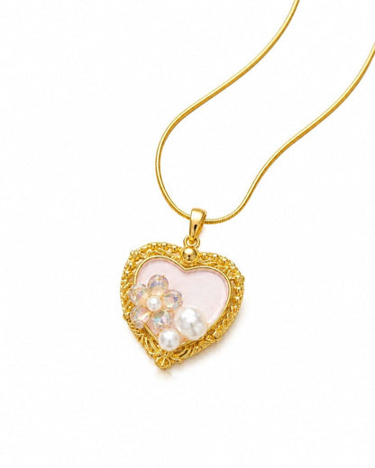 Gold heart-shaped pendant necklace with pink center, iridescent floral crystals, white pearls, and delicate chain on white background 1